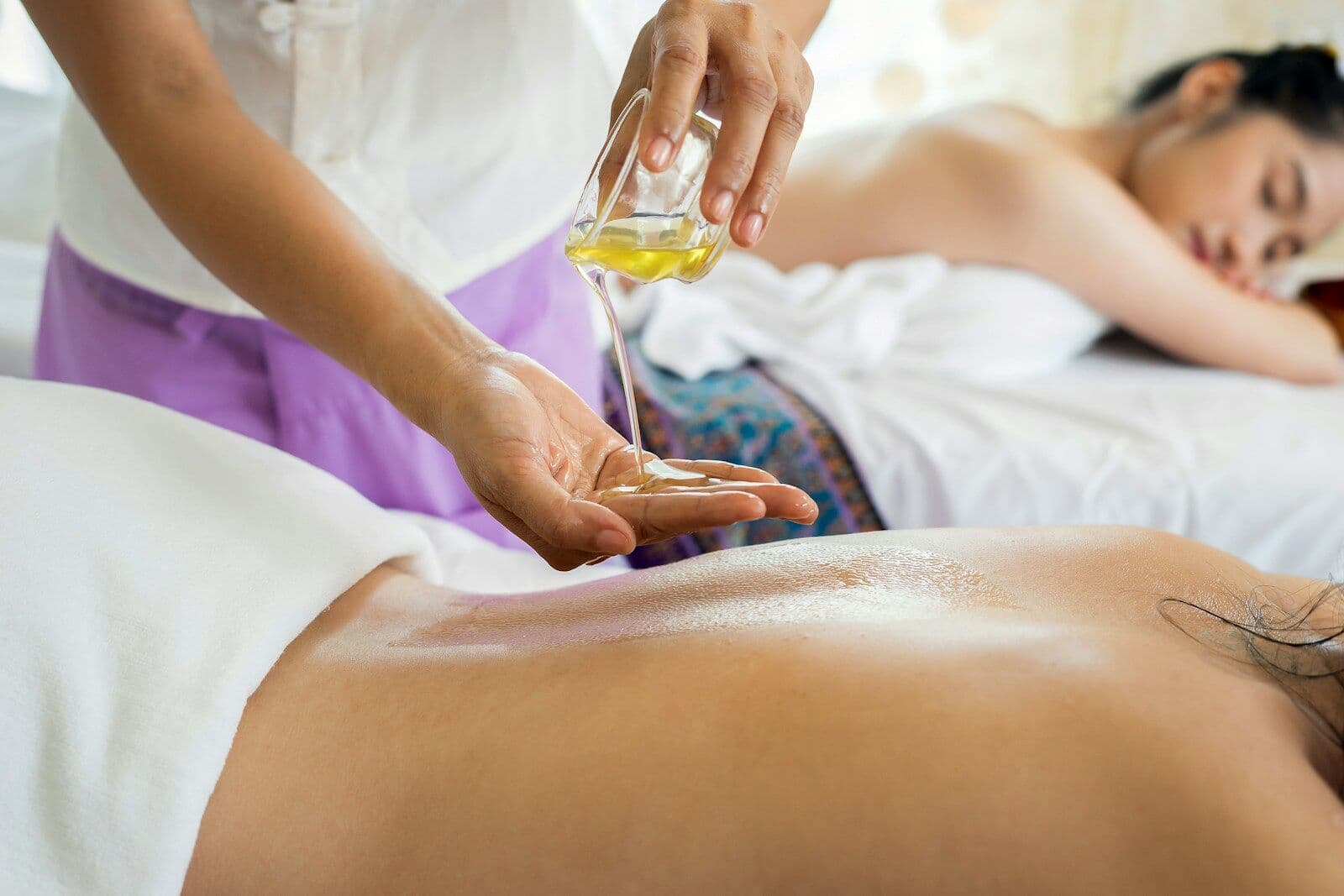 Therapist pouring warm aromatherapy oil during a back massage at Riva Wellness Spa in Sector 41, Gurugram